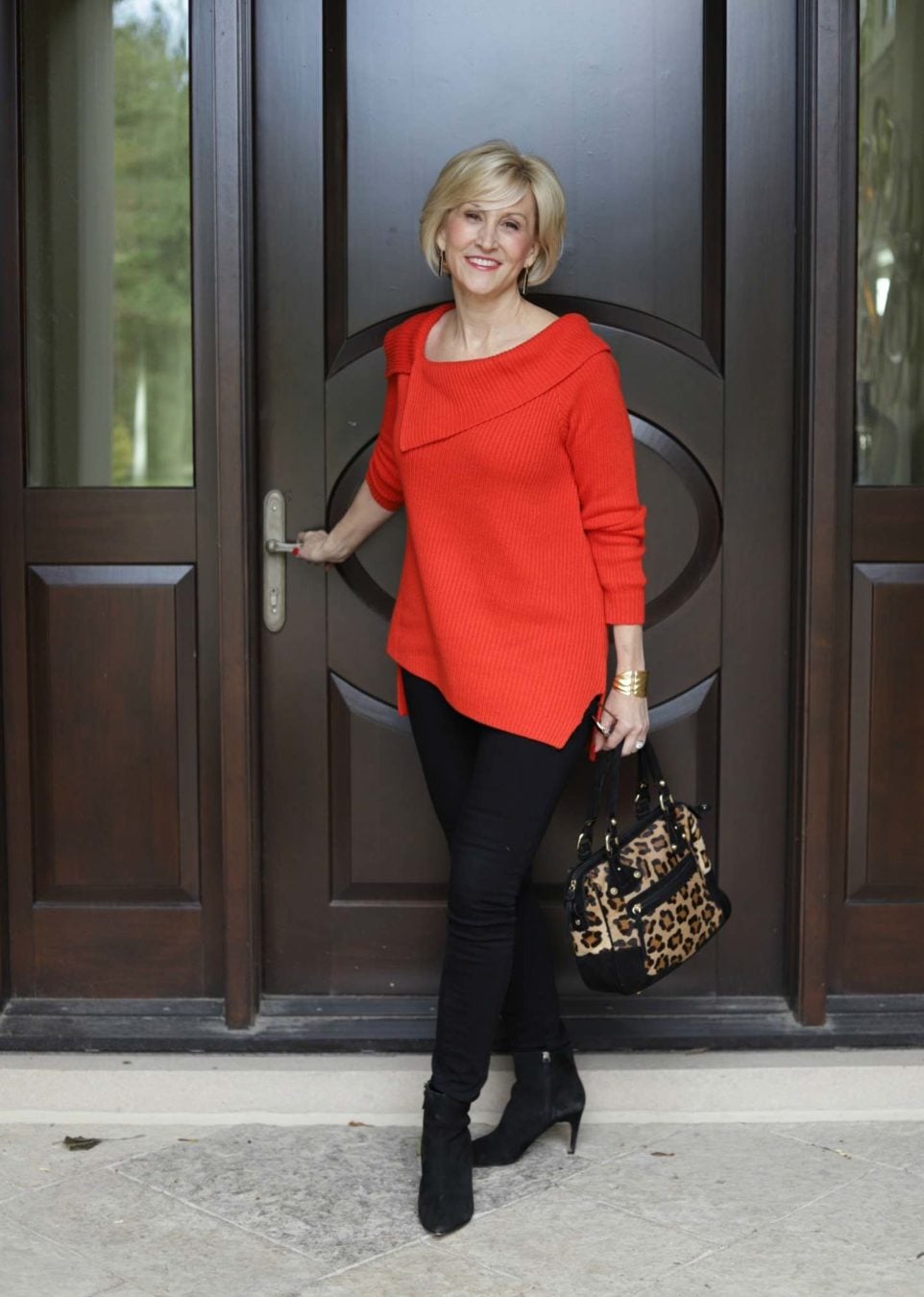 black ponte leggings, orange symmetrial tunic sweater worn by Deborah Boland from Fabulous After 40